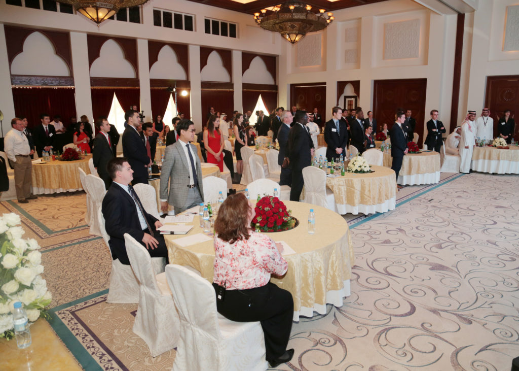 Evento formal con asistentes sentados alrededor de mesas redondas.